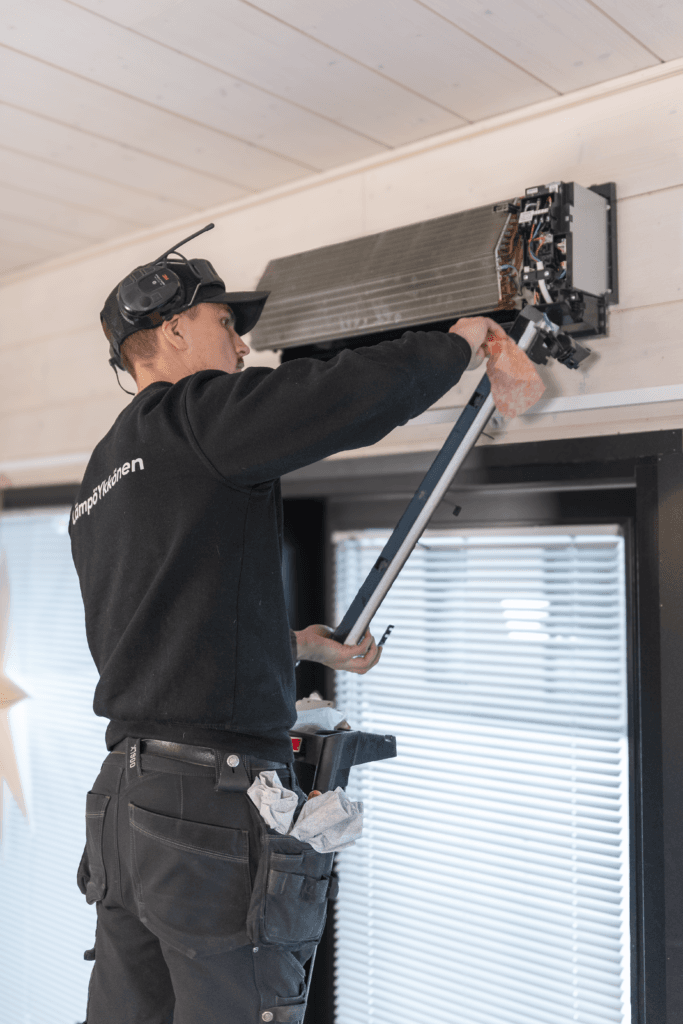 Huoltomies huoltaa ilmalämpöpumppua