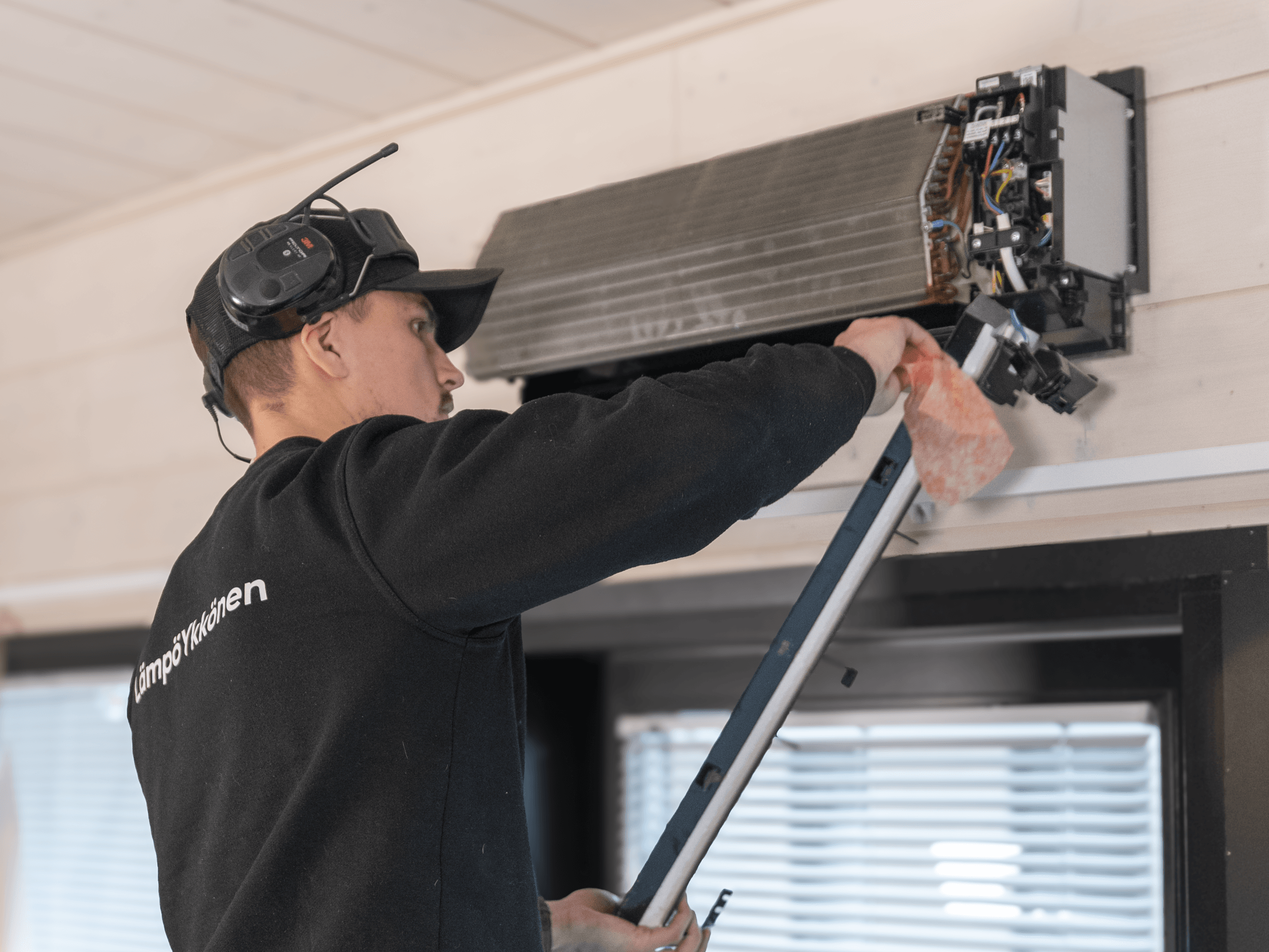 Huoltomies huoltaa ilmalämpöpumppua