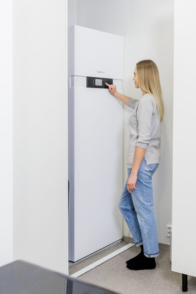 Nainen käyttää ilma-vesillämpöpumppua